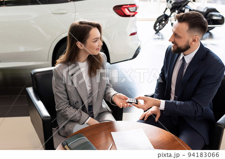 car dealership manager handing over keys to new car buyer. the concept of buying a car on lease 94183066