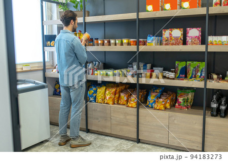 Shop owner putting products on the selves and looking involved 94183273