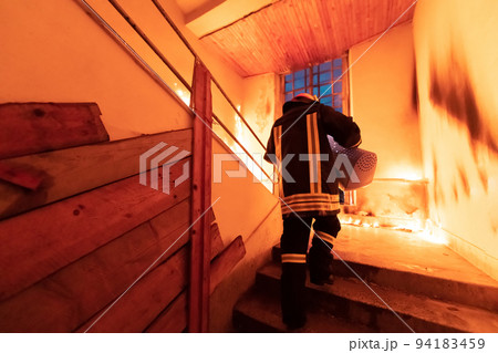 Firefighter hero carrying cat pet animal in carrying bag box out from burning building area from the fire incident. Rescue animal from a dangerous place. Teamwork concept.  94183459