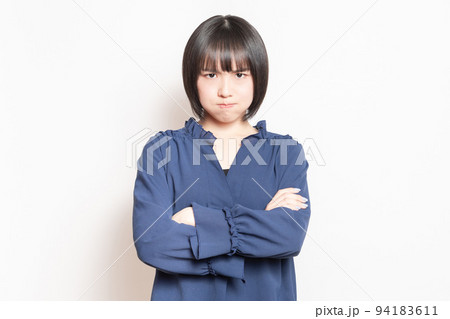 白背景の前に立って、怒っている若い女性 94183611