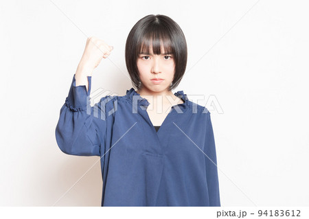 白背景の前に立って、怒っている若い女性 94183612