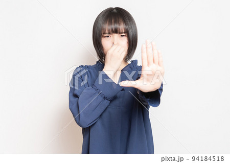 悪臭に困って鼻をつまんでいる若い女性 94184518