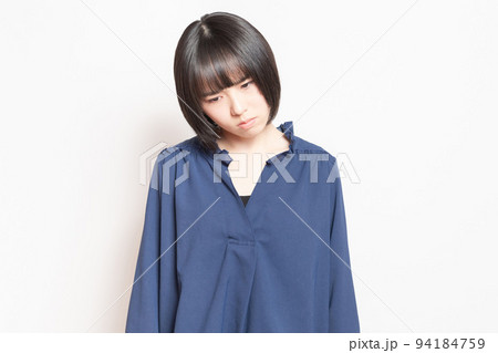 白バックの前で、落ち込んでいる若い女性 白バックの前で、落ち込んでいる若い女性 94184759