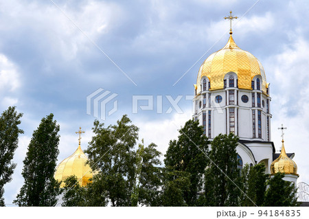 The golden domes of the church and the cloud blue sky on a warm Easter day 94184835