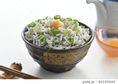 しょうがをのせた釜揚げしらす丼とお箸と醤油差しと生卵(白背景) しょうがをのせた釜揚げしらす丼とお箸と醤油差しと生卵(白背景) 94185644