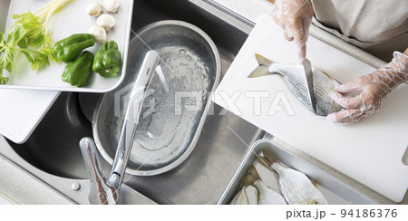 キッチンで魚を料理する日本人の主婦の手元、釣魚のヘダイを料理する 94186376