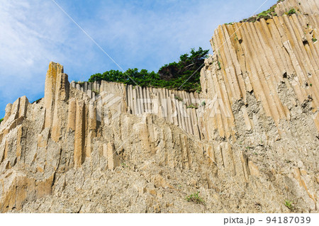 high coastal cliff made of columnar granite, landscape on the island of Kunashir high coastal cliff made of columnar granite, landscape on the island of Kunashir 94187039