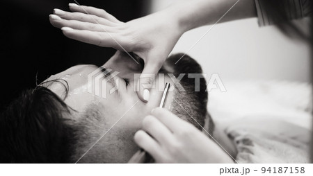 Barber shaves the bearded man Barber shaves the bearded man 94187158