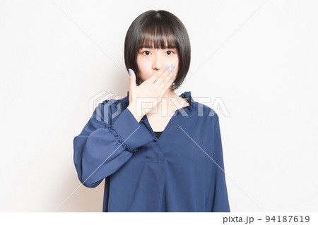口を手で隠して内緒のポーズをする若い女性 口を手で隠して内緒のポーズをする若い女性 94187619