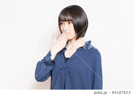 口を手で隠して内緒のポーズをする若い女性 口を手で隠して内緒のポーズをする若い女性 94187623