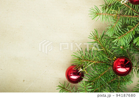 Fir tree branches decorated with red christmas balls as border on a rustic holiday background frame with copy space Fir tree branches decorated with red christmas balls as border on a rustic holiday background frame with copy space 94187680