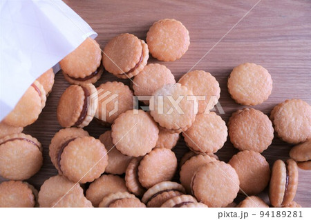 テーブルにこぼれ落ちた沢山のビスケット ジャムサンドクッキー テーブルにこぼれ落ちた沢山のビスケット ジャムサンドクッキー 94189281