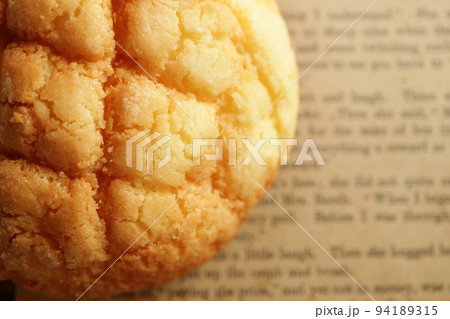 こんがり焼けたカリカリのメロンパン　背景英文紙 94189315