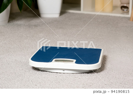 Blue floor scales on the gray carpet in the room. The idea of losing weight and controlling a person's weight 94190815