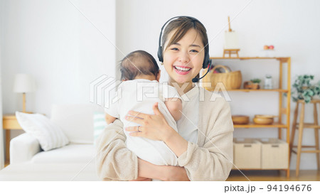 赤ちゃんを抱っこしながらビデオ通話で話す女性 赤ちゃんを抱っこしながらビデオ通話で話す女性 94194676