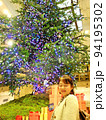 クリスマスツリーの下で微笑む女性 94195302