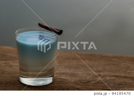 A glass of Blue matcha latte tea or Butterfly pea flower milk tea latte from the dried flowers of the butterfly pea plant (clitoria). A glass of Blue matcha latte tea or Butterfly pea flower milk tea latte from the dried flowers of the butterfly pea plant (clitoria). 94195470
