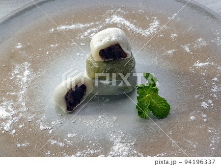 Red bean and Green tea daifuku serve with Mint leaves on Round ceramic tray. 94196337