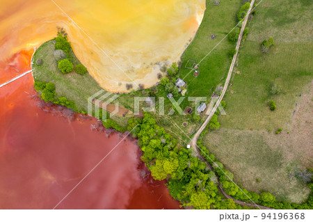 Aerial view of red waste water and green forest 94196368