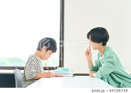 勉強を教える女性 勉強をする小学生 勉強を教える女性 勉強をする小学生 94196749