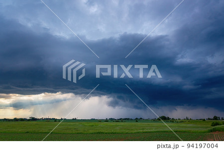 Storm clouds over field, tornadic supercell, extreme weather, dangerous storm Storm clouds over field, tornadic supercell, extreme weather, dangerous storm 94197004