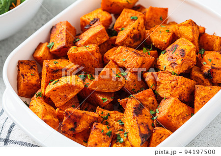 Spicy slices of baked sweet potato. Vegan food concept. 94197500