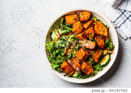 Baked sweet potato salad bowl with mustard dressing. Vegan food concept. 94197502