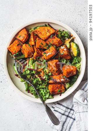 Baked sweet potato salad bowl with mustard dressing. Vegan food concept. 94197503