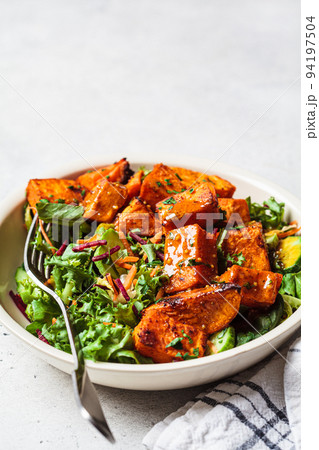 Baked sweet potato salad bowl with mustard dressing. Vegan food concept. 94197504