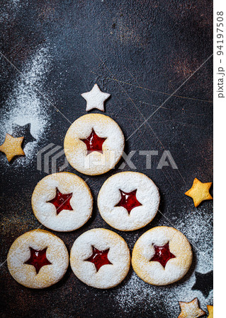 Christmas tree from strawberry linzer cookies on dark background. Festive dessert, winter treat. 94197508