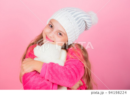 Kid cute girl play with soft toy teddy bear pink background. Child small girl playful hold teddy bear plush toy. Unique attachments to stuffed animals. Teddy bears improve psychological wellbeing 94198224