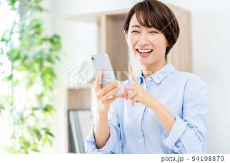 リビングでスマホを操作するミドル女性 リビングでスマホを操作するミドル女性 94198870
