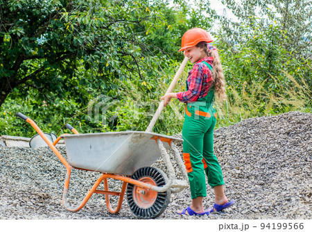 Future profession. future engineer. happy kid use construction wheelbarrow. building construction site. child architect worker. labor day concept. childhood development. teenager girl assistant Future profession. future engineer. happy kid use construction wheelbarrow. building construction site. child architect worker. labor day concept. childhood development. teenager girl assistant 94199566