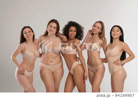 Group of women with different body types in jeans and underwear taking selfie against light Group of women with different body types in jeans and underwear taking selfie against light 94199907