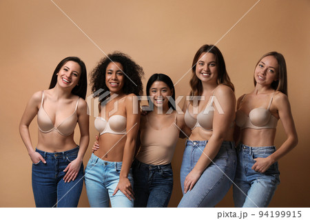 Group of women with different body types in jeans and underwear on beige background Group of women with different body types in jeans and underwear on beige background 94199915
