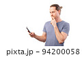 Man looks thoughtfully at his smartphone and rubs his chin. Concept of internet communication, fraud, discretion Man looks thoughtfully at his smartphone and rubs his chin. Concept of internet communication, fraud, discretion 94200058
