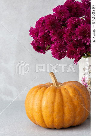 Brown pumpkin with a bouquet of chrysonhemums 94200897