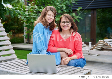 Portrait of happy mom and teenage daughter looking at camera Portrait of happy mom and teenage daughter looking at camera 94201050
