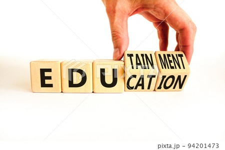 Education and edutainment symbol. Concept words Education and edutainment on wooden cubes. Teacher hand. Beautiful white table white background. Education and edutainment concept. Copy space. 94201473