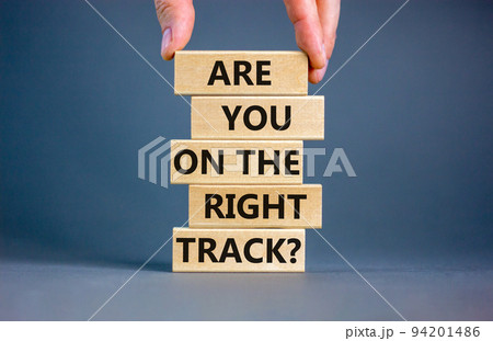 Right track symbol. Concept words Are you on the right track on wooden blocks on a beautiful grey table grey background. Businessman hand. Business motivational and right track concept. Right track symbol. Concept words Are you on the right track on wooden blocks on a beautiful grey table grey background. Businessman hand. Business motivational and right track concept. 94201486