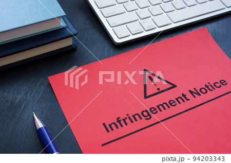 Infringement notice near a keyboard and notepads. 94203343