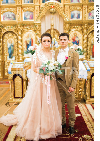 Married couple posing in a church after ceremony 94203538