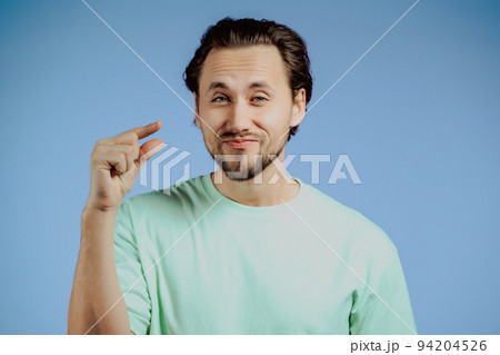 Young man showing invisible abstract small subject or object. Tiny concept. Young man showing invisible abstract small subject or object. Tiny concept. 94204526