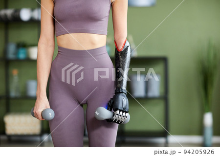 Woman with disability exercising with dumbbells 94205926