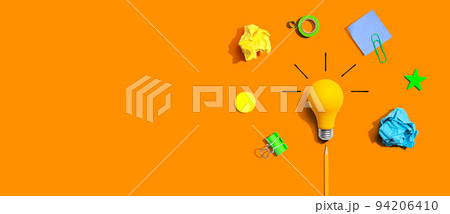 Brainstorming concept with a light bulb and school supplies - Flat lay Brainstorming concept with a light bulb and school supplies - Flat lay 94206410