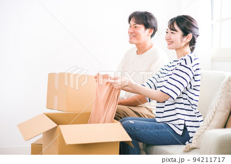 引越し作業で段ボールに荷物を詰める夫婦 引越し作業で段ボールに荷物を詰める夫婦 94211717