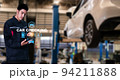 Asian man fix Technology AI fix car repair on car Lift in garage dealership Fix the car with a touch touching UI screen interface point to the point  corrected New technology in IOT car industry 94211888