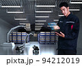 Asian Man Engineer hold smartphone touch touching UI screen interface for manufacturing industry technology Product export and import future Robot cyber warehouse arm robot future technology 94212019