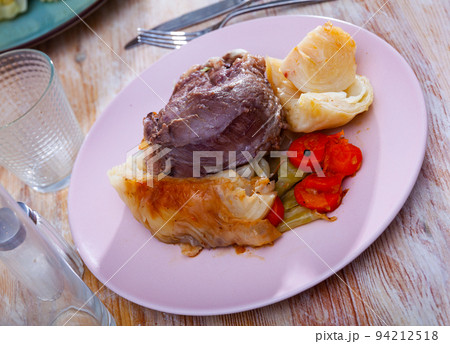 Delicious baked in sauce pork cheeks served cabbage and carrot Delicious baked in sauce pork cheeks served cabbage and carrot 94212518