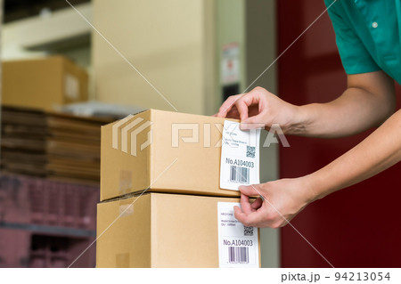 出荷前にラベルを手で貼り付ける男性 94213054